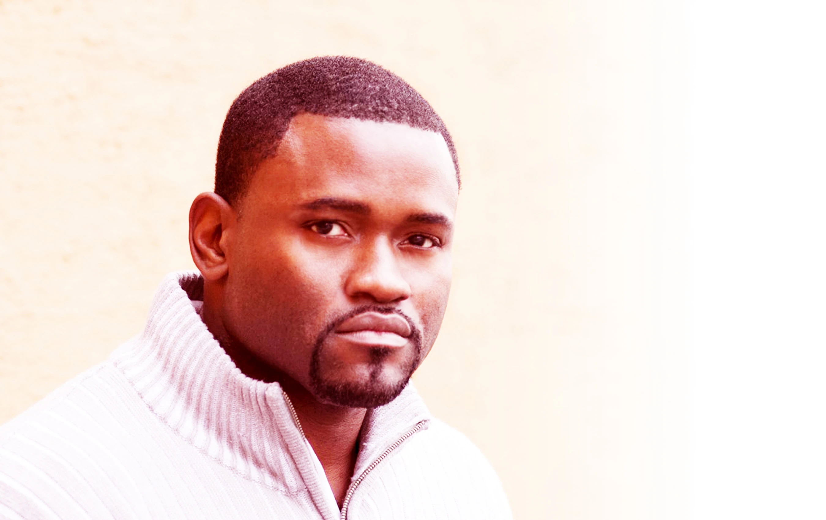 Ron Denson in a light sweater, in a three-quarter pose